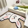 Tapis descente de lit gros lapin blanc dans une chambre d'enfant.