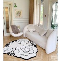 Décoration salle de séjour sublimée par un tapis moderne motif de fleurs de camélia.