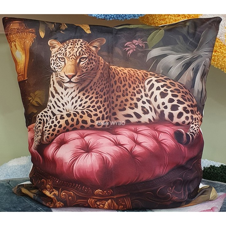 Coussin décoratif jungle et animaux sauvages, panthère sur sofa rouge.