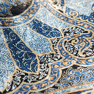 tapis de luxe en soie naturelle loué à la main motif symétrique fleurs et feuilles bleu.