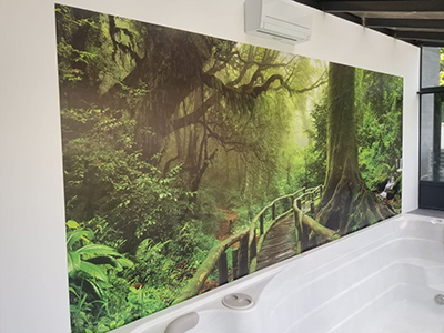 Décoration salle de bain moderne avec SPA, revêtement mural étanche pour habiller un grand mur de baignoire, paysage panoramique trompe l'œil 3d arbre géant et passerelle en bois dans la forêt primaire.
