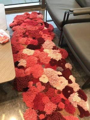tapis séjour fleurs rouge et rose forme irrégulière en laine et fibre textile tufté à la main velours sculpté par ciselure en relief.